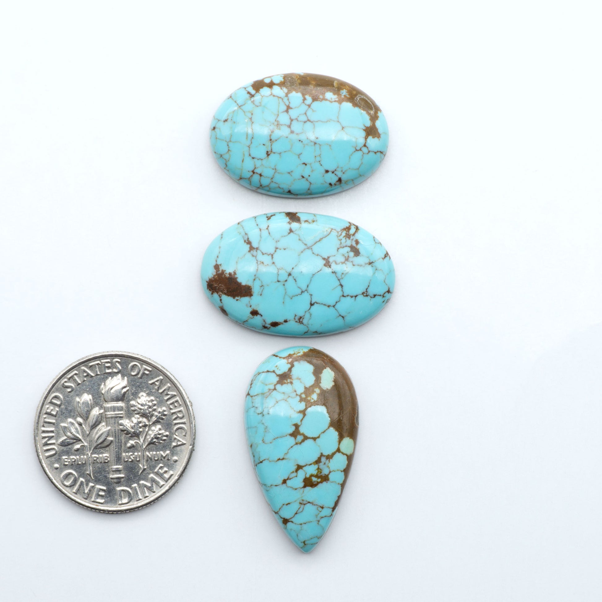 Number 8 Turquoise cabochons, blue and green color with brown matrix, polished stones on a white background, with a US dime for scale
