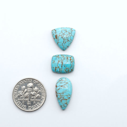 Number 8 Turquoise cabochons, blue and green color with brown matrix, polished stones on a white background, with a US dime for scale