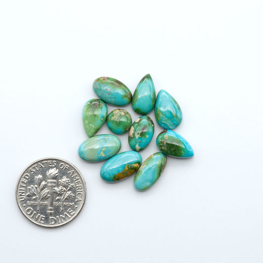 Sonoran Mountain Turquoise cabochons, blue-green color with natural matrix, polished stones on a white background, with a US dime for scale