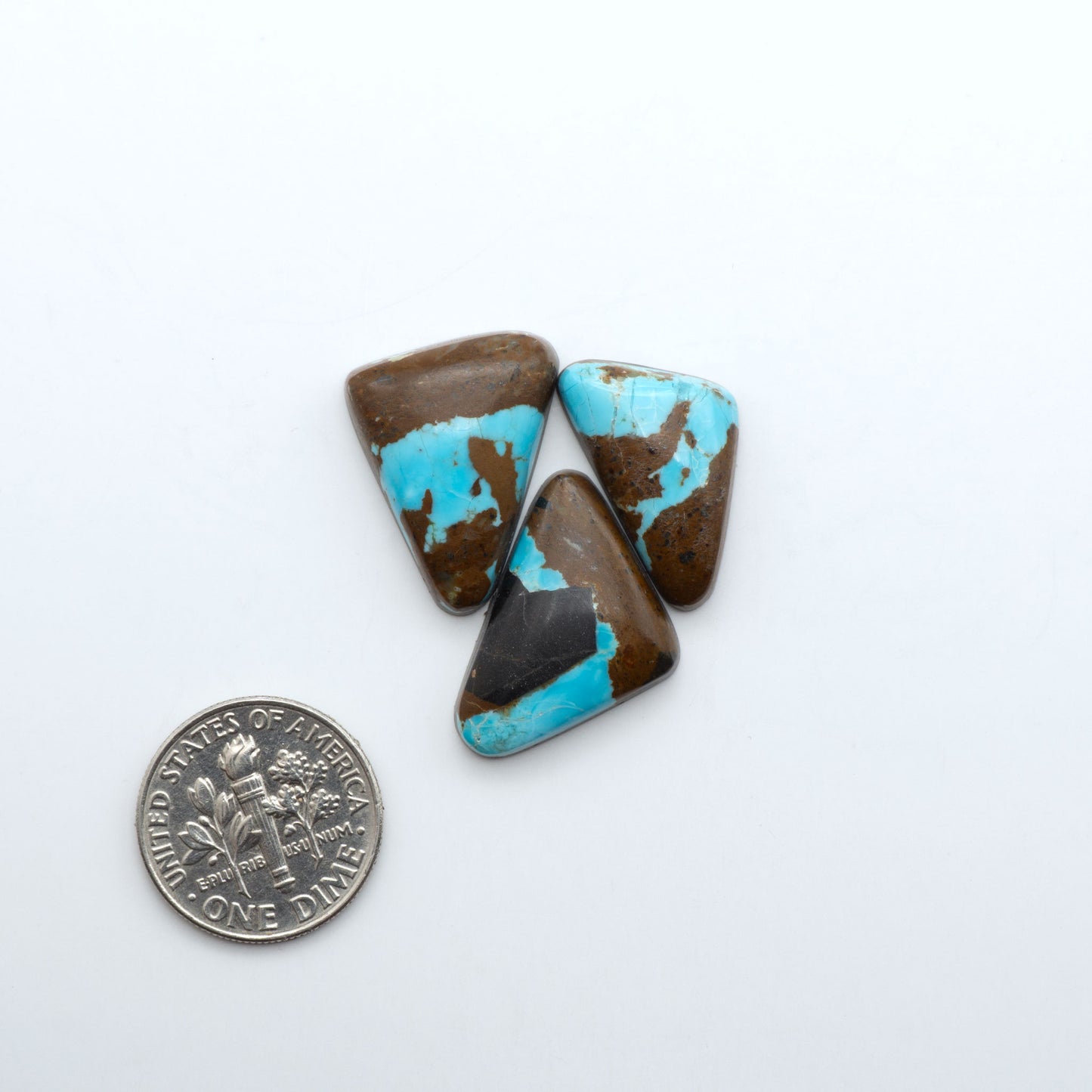 Number 8 Turquoise cabochons, blue and green color with brown matrix, polished stones on a white background, with a US dime for scale