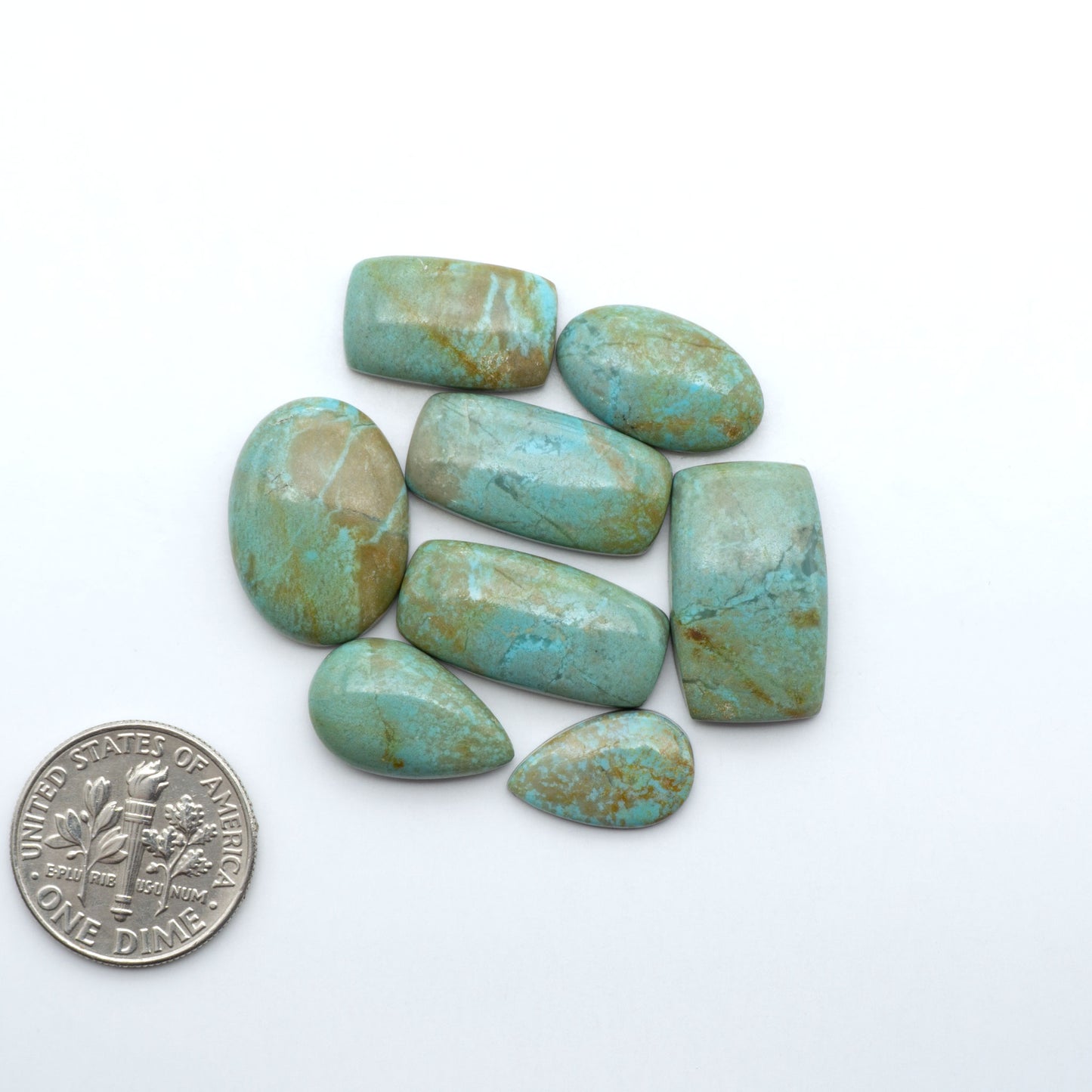 Number 8 Turquoise cabochons, blue and green color with brown matrix, polished stones on a white background, with a US dime for scale