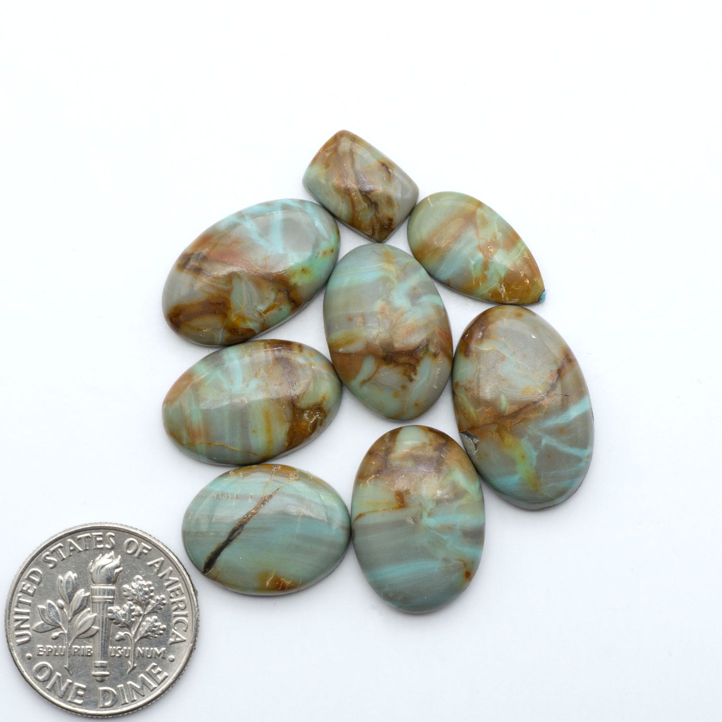 Number 8 Turquoise cabochons, blue and green color with brown matrix, polished stones on a white background, with a US dime for scale