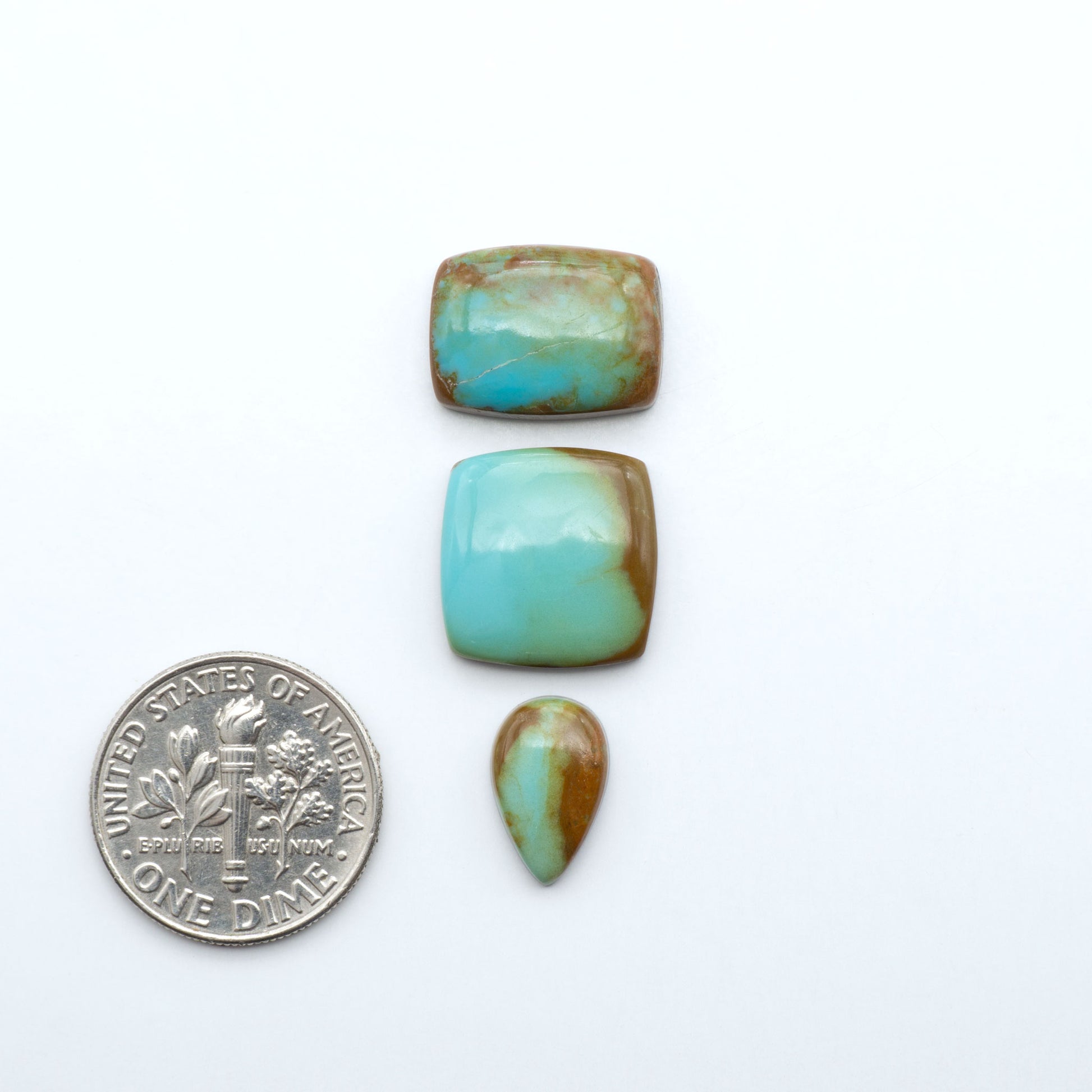 Number 8 Turquoise cabochons, blue and green color with brown matrix, polished stones on a white background, with a US dime for scale
