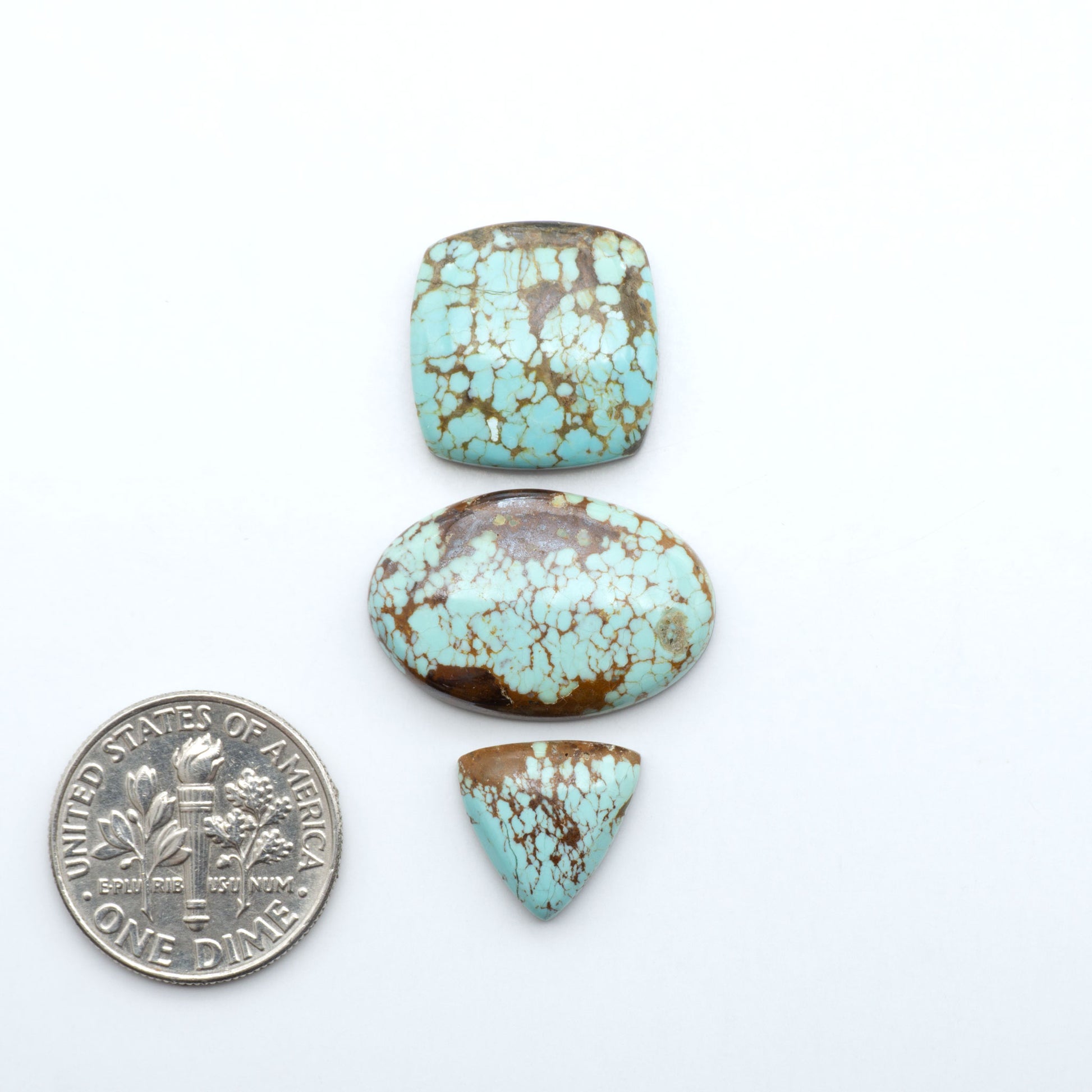 Number 8 Turquoise cabochons, blue and green color with brown matrix, polished stones on a white background, with a US dime for scale