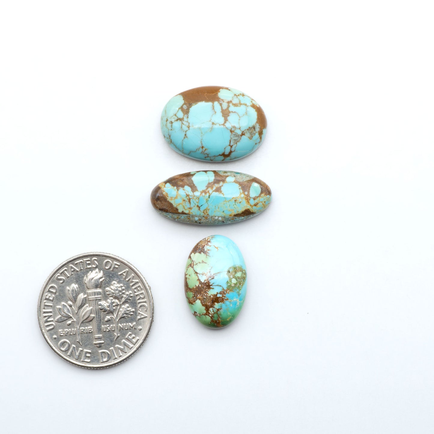 Number 8 Turquoise cabochons, blue and green color with brown matrix, polished stones on a white background, with a US dime for scale