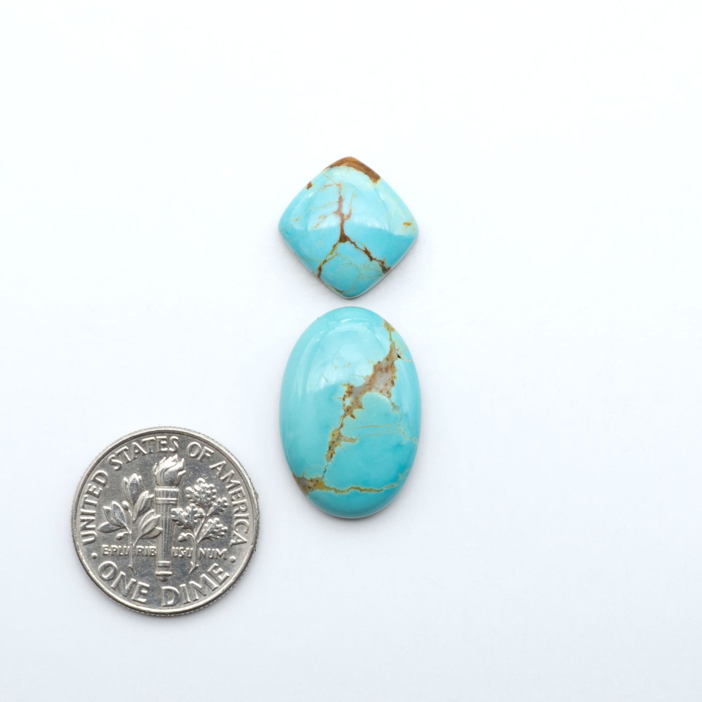 Number 8 Turquoise cabochons, blue and green color with brown matrix, polished stones on a white background, with a US dime for scale