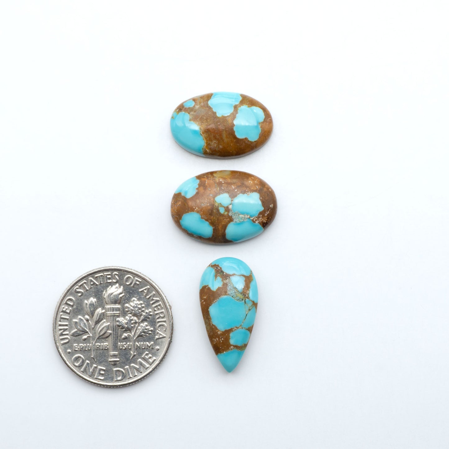 Number 8 Turquoise cabochons, blue and green color with brown matrix, polished stones on a white background, with a US dime for scale