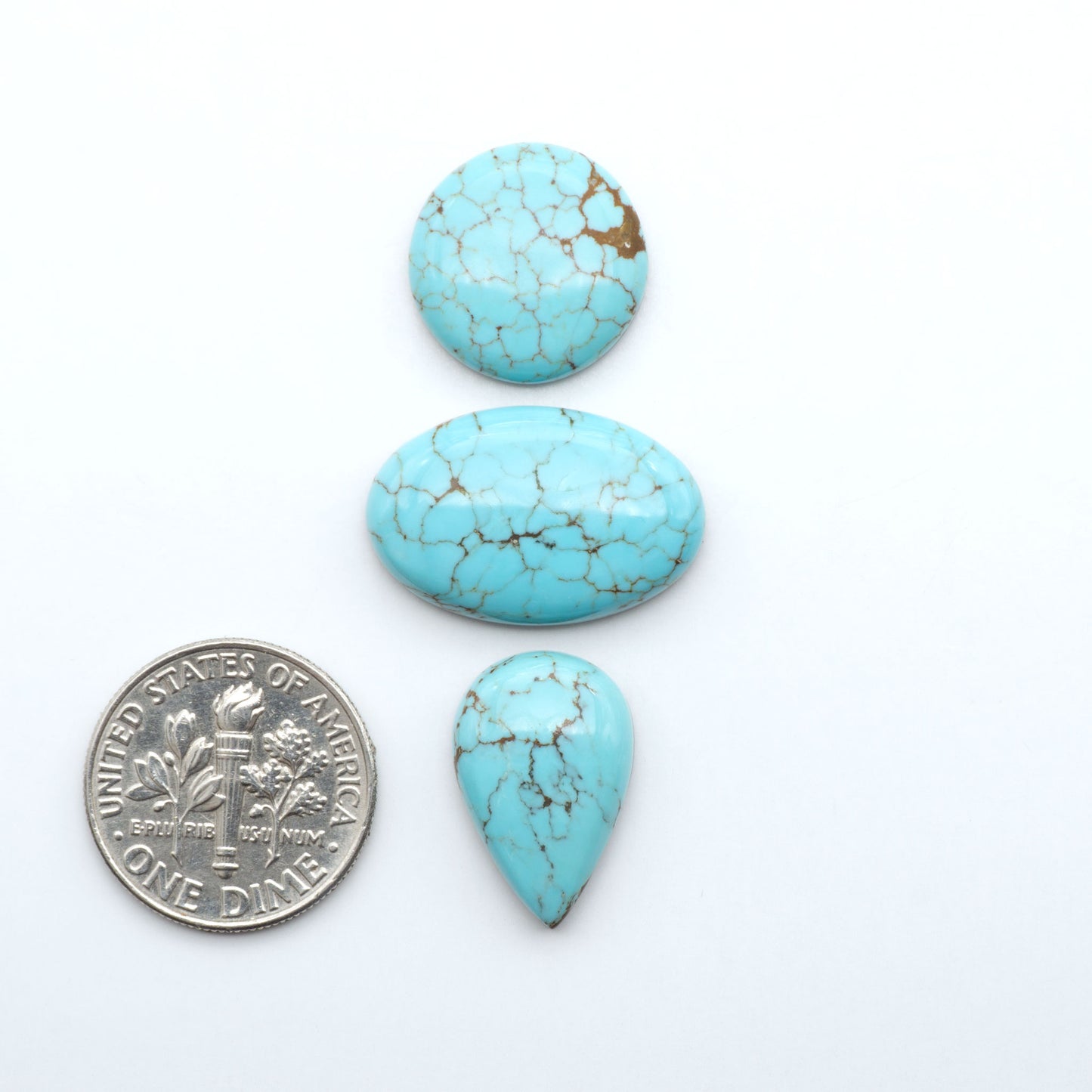 Number 8 Turquoise cabochons, blue and green color with brown matrix, polished stones on a white background, with a US dime for scale