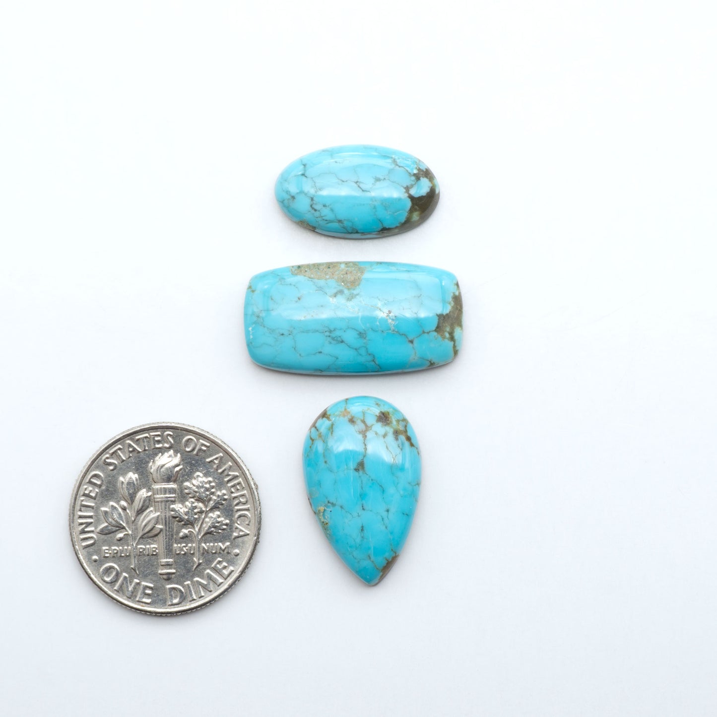 Number 8 Turquoise cabochons, blue and green color with brown matrix, polished stones on a white background, with a US dime for scale