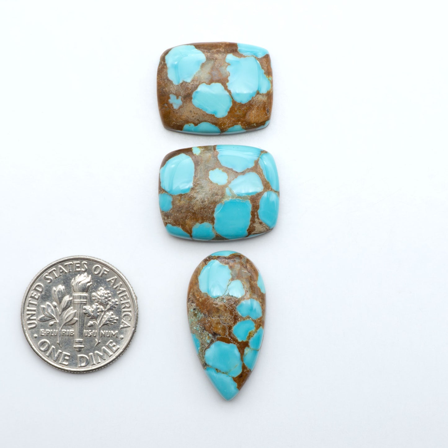 Number 8 Turquoise cabochons, blue and green color with brown matrix, polished stones on a white background, with a US dime for scale