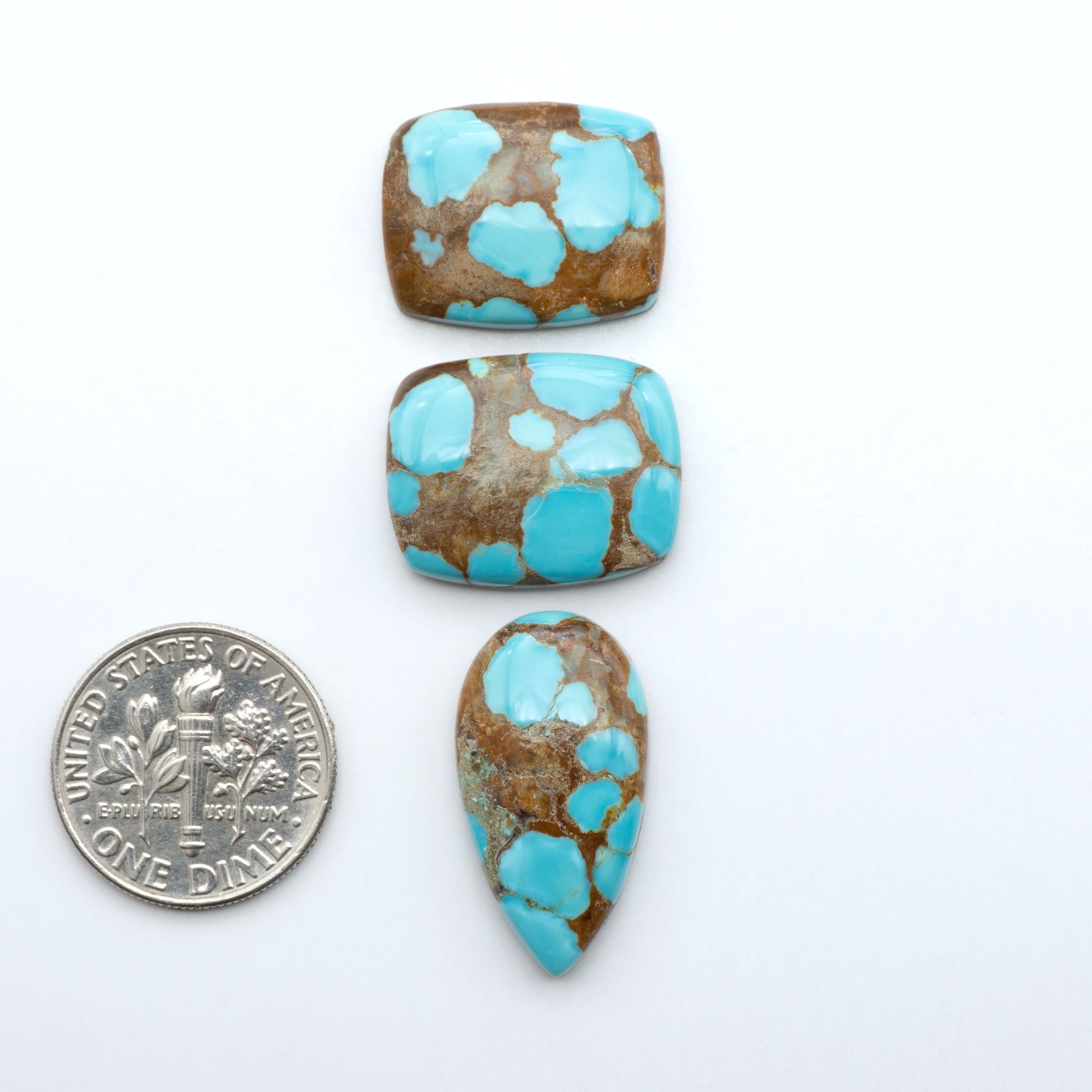 Number 8 Turquoise cabochons, blue and green color with brown matrix, polished stones on a white background, with a US dime for scale