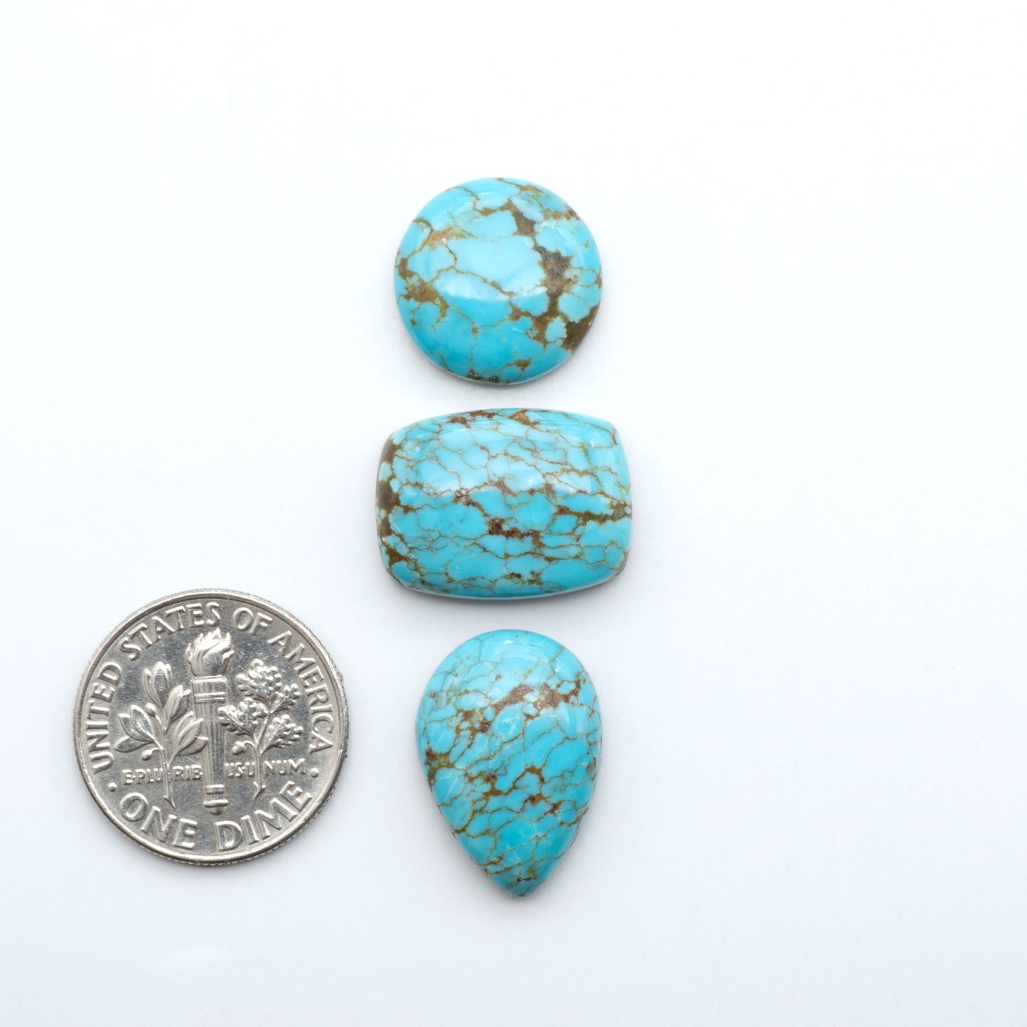 Number 8 Turquoise cabochons, blue and green color with brown matrix, polished stones on a white background, with a US dime for scale