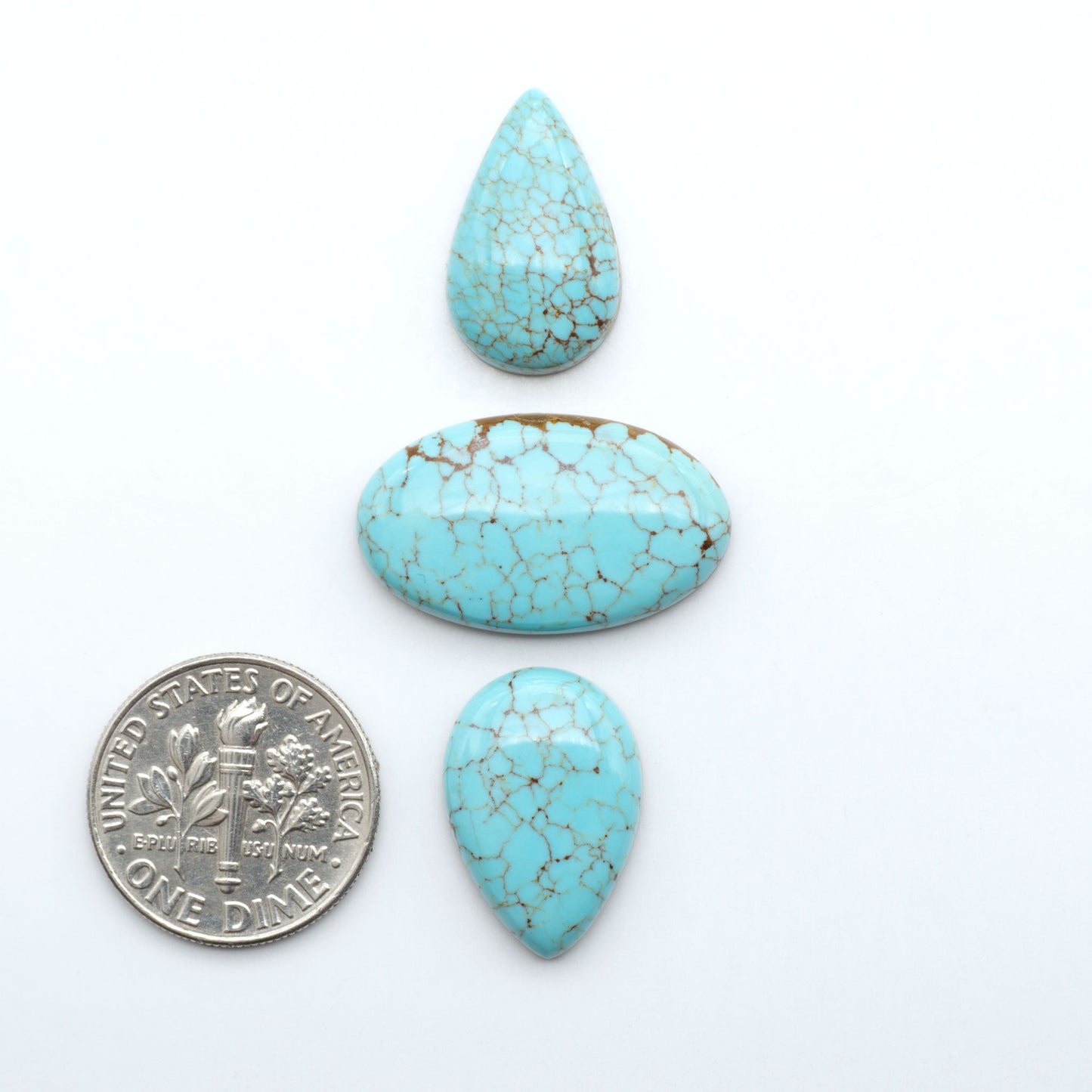 Number 8 Turquoise cabochons, blue and green color with brown matrix, polished stones on a white background, with a US dime for scale