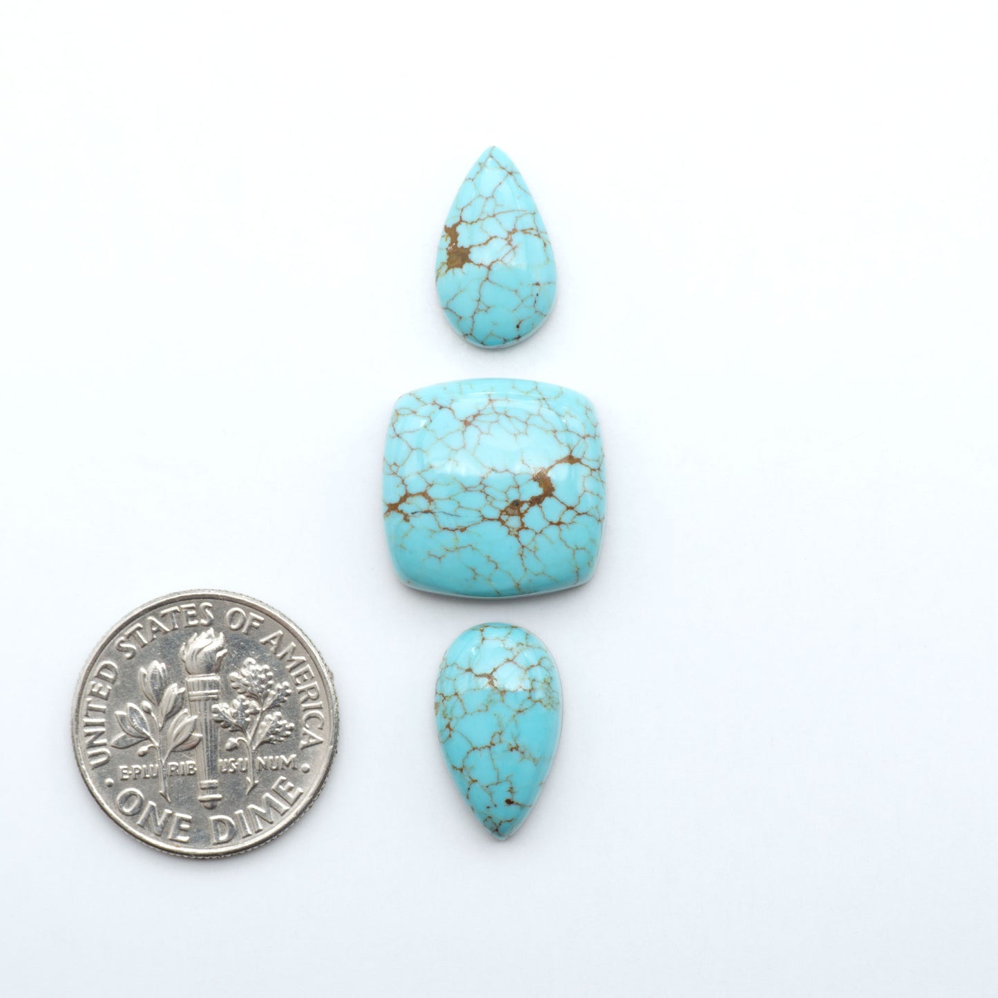 Number 8 Turquoise cabochons, blue and green color with brown matrix, polished stones on a white background, with a US dime for scale