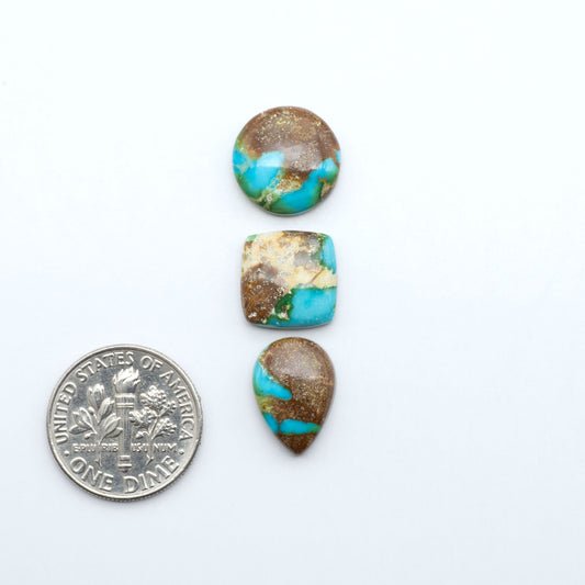 Sonoran Mountain Turquoise cabochons, blue-green color with natural matrix, polished stones on a white background, with a US dime for scale