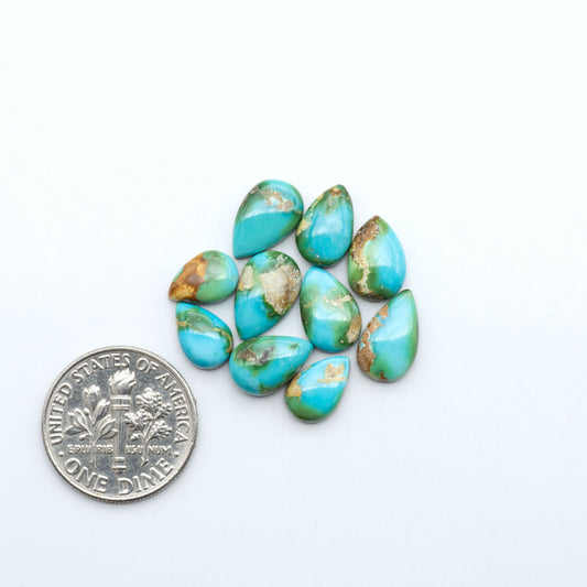 Sonoran Mountain Turquoise cabochons, blue-green color with natural matrix, polished stones on a white background, with a US dime for scale