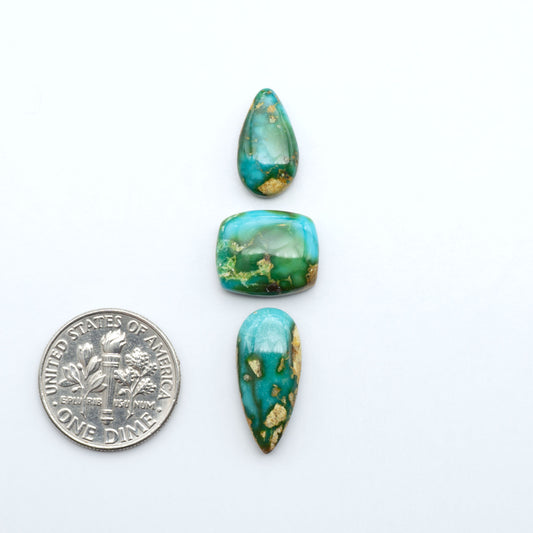 Sonoran Mountain Turquoise cabochons, blue-green color with natural matrix, polished stones on a white background, with a US dime for scale