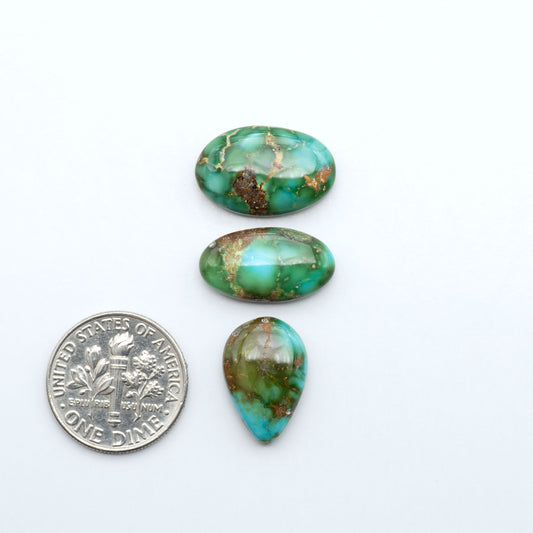 Sonoran Mountain Turquoise cabochons, blue-green color with natural matrix, polished stones on a white background, with a US dime for scale
