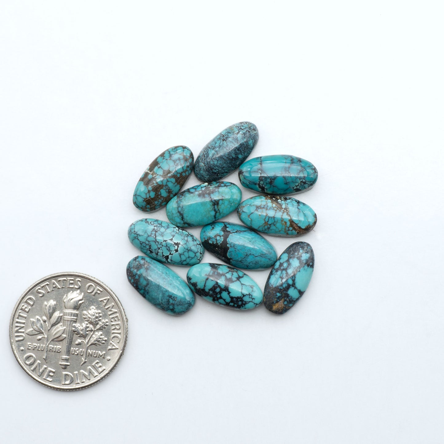 Hubei Cloud Mountain Turquoise cabochons, blue and green color with black matrix, polished stones on a white background with a US dime for scale