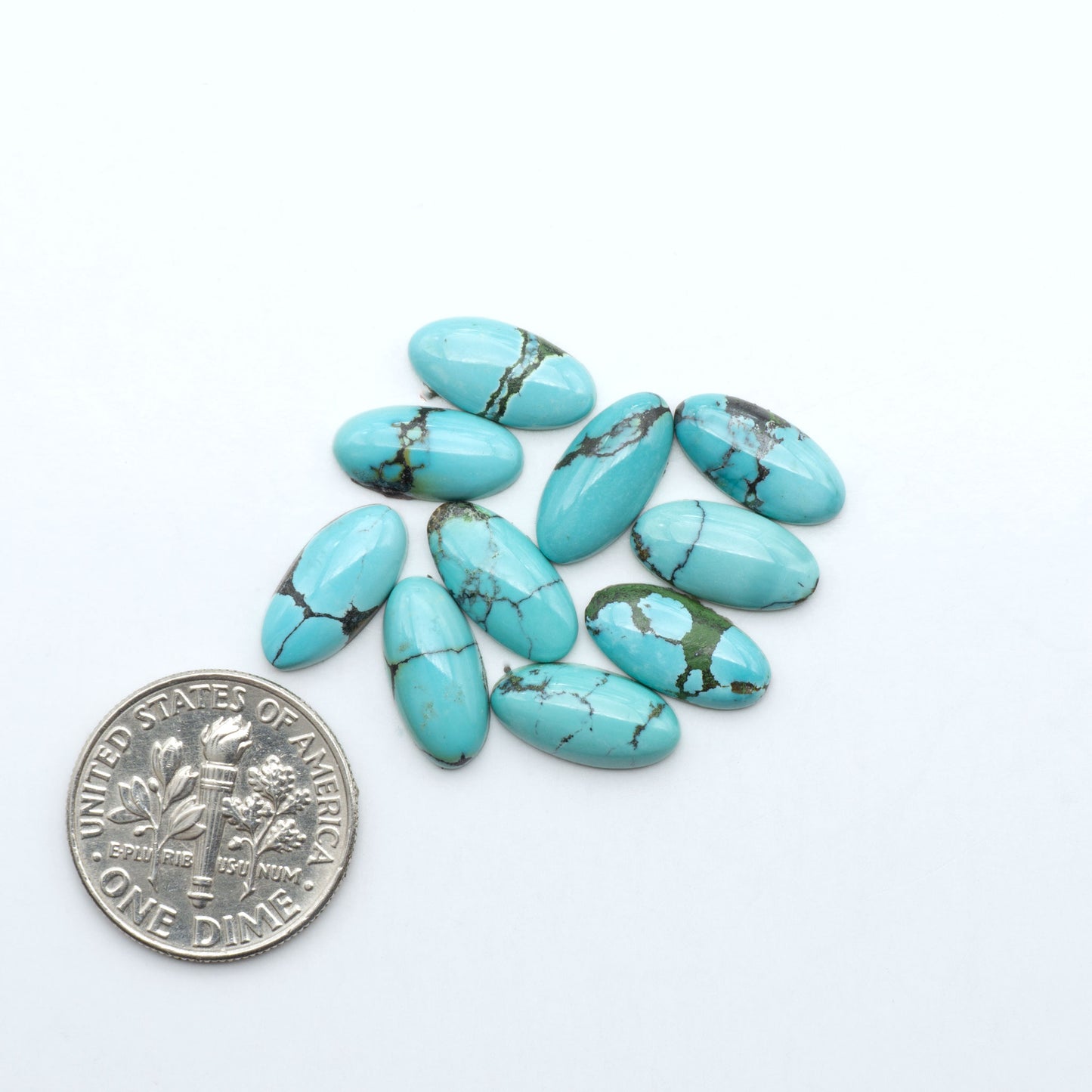 Hubei Cloud Mountain Turquoise cabochons, blue and green color with black matrix, polished stones on a white background with a US dime for scale