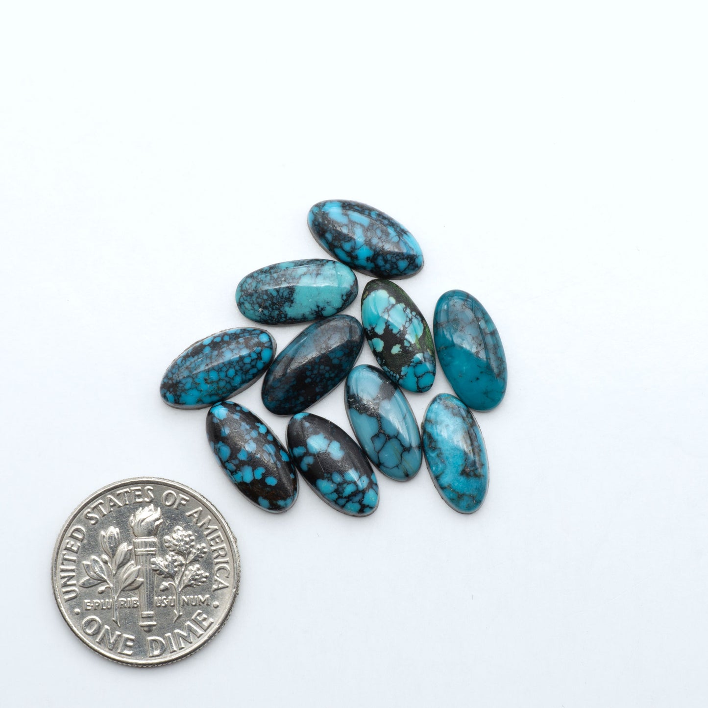 Hubei Cloud Mountain Turquoise cabochons, blue and green color with black matrix, polished stones on a white background with a US dime for scale