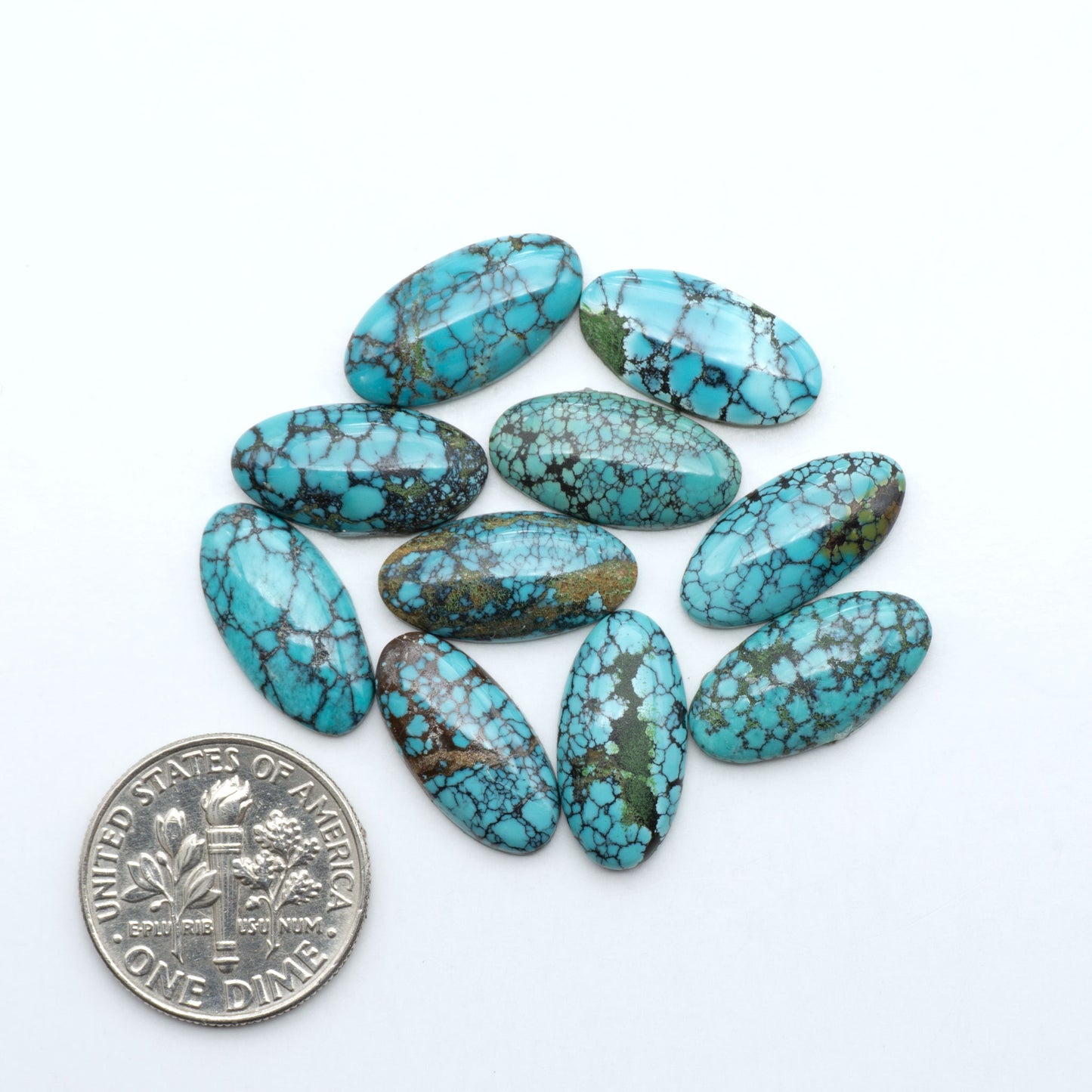 Hubei Cloud Mountain Turquoise cabochons, blue and green color with black matrix, polished stones on a white background with a US dime for scale