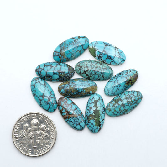 Hubei Cloud Mountain Turquoise cabochons, blue and green color with black matrix, polished stones on a white background with a US dime for scale
