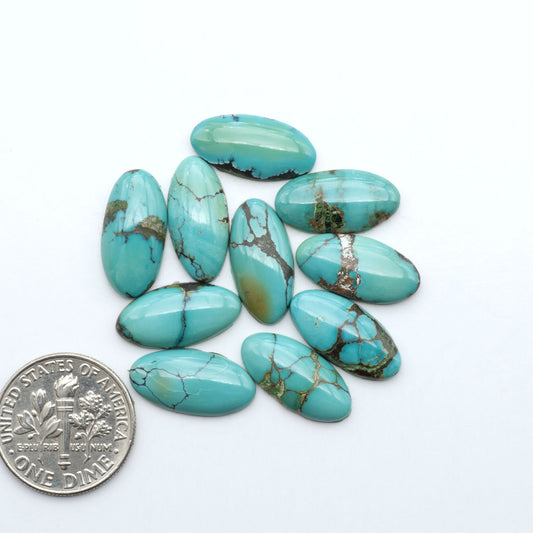 Hubei Cloud Mountain Turquoise cabochons, blue and green color with black matrix, polished stones on a white background with a US dime for scale