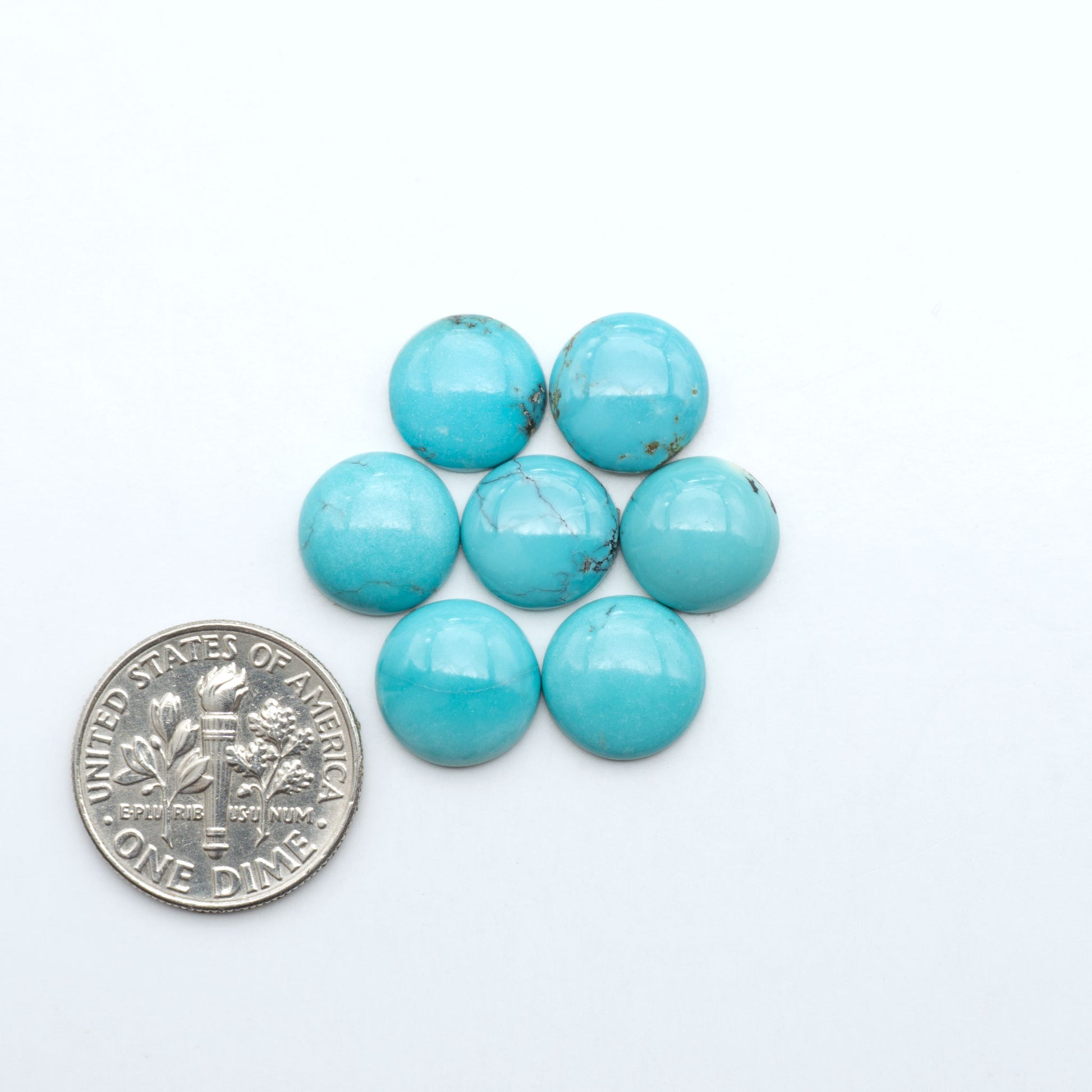Hubei Cloud Mountain Turquoise cabochons, blue and green color with black matrix, polished stones on a white background with a US dime for scale