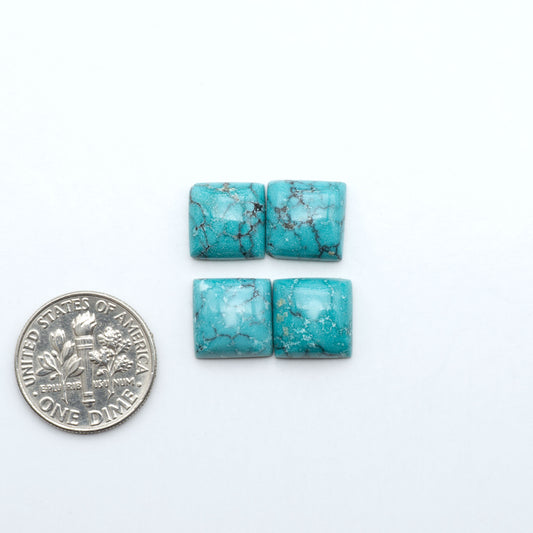 Hubei Cloud Mountain Turquoise cabochons, blue and green color with black matrix, polished stones on a white background with a US dime for scale