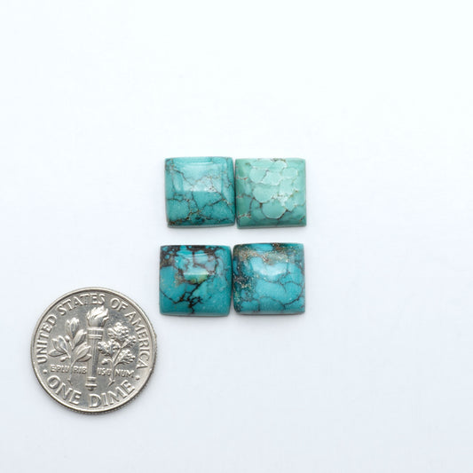Hubei Cloud Mountain Turquoise cabochons, blue and green color with black matrix, polished stones on a white background with a US dime for scale