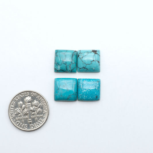 Hubei Cloud Mountain Turquoise cabochons, blue and green color with black matrix, polished stones on a white background with a US dime for scale