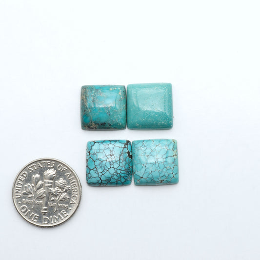 Hubei Cloud Mountain Turquoise cabochons, blue and green color with black matrix, polished stones on a white background with a US dime for scale
