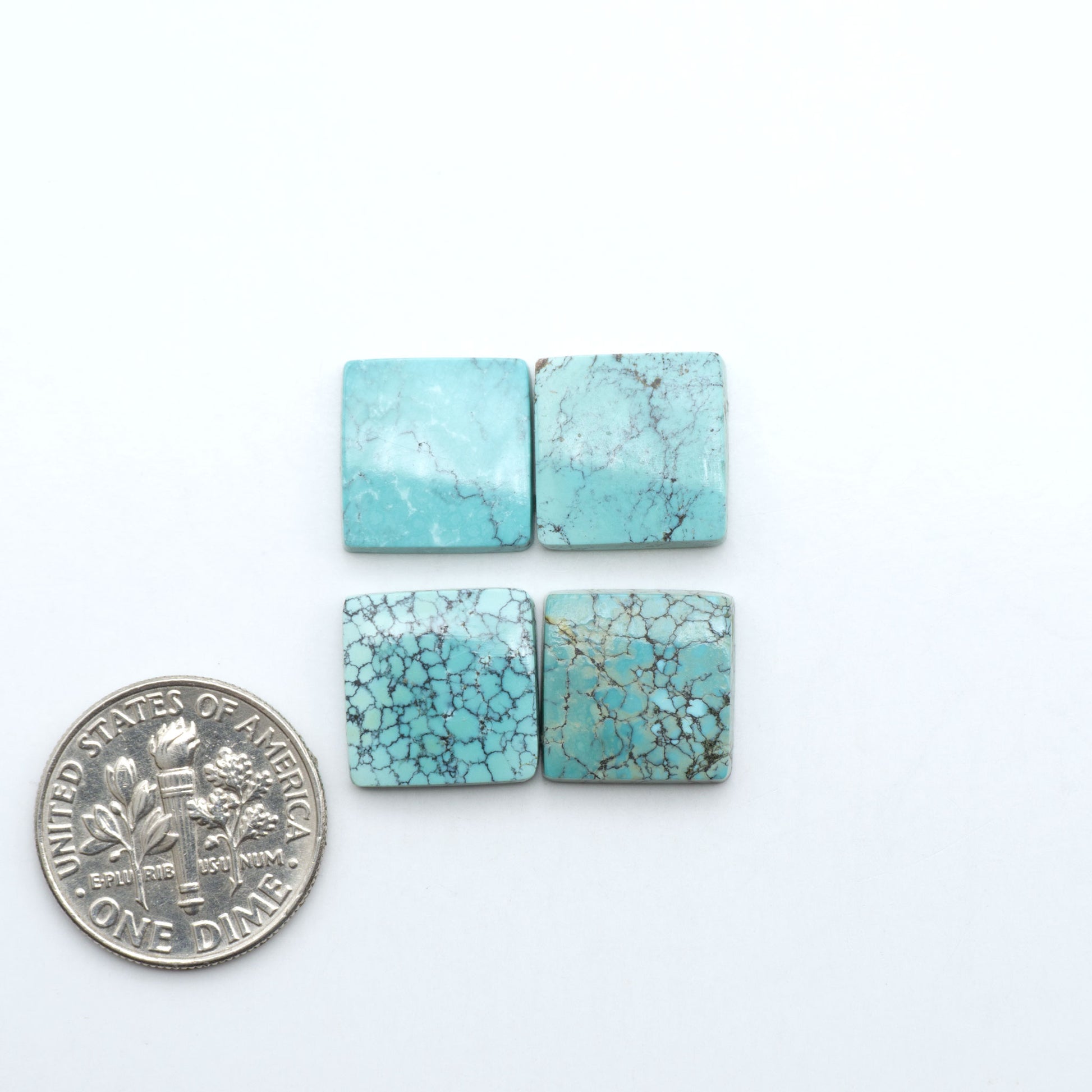 Hubei Cloud Mountain Turquoise cabochons, blue and green color with black matrix, polished stones on a white background with a US dime for scale