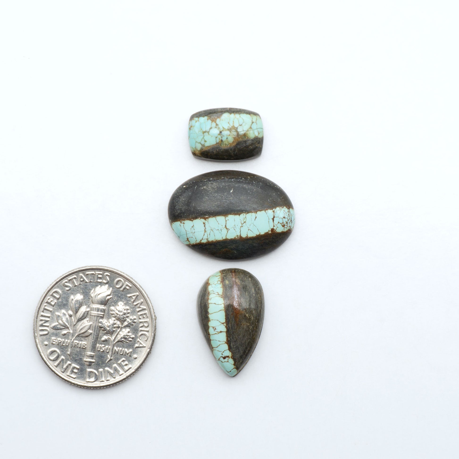Number 8 Turquoise cabochons, blue and green color with brown matrix, polished stones on a white background, with a US dime for scale