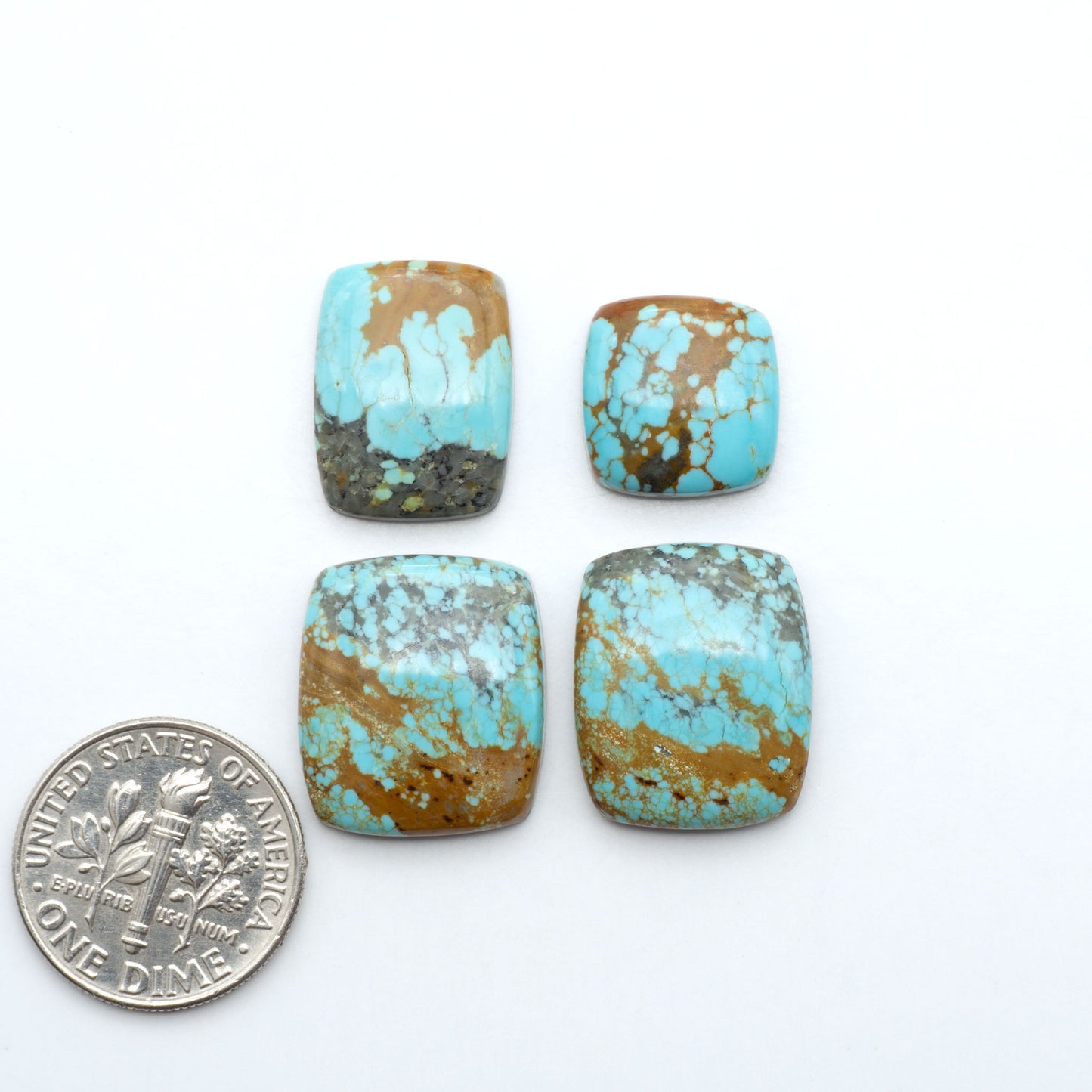 Number 8 Turquoise cabochons, blue and green color with brown matrix, polished stones on a white background, with a US dime for scale