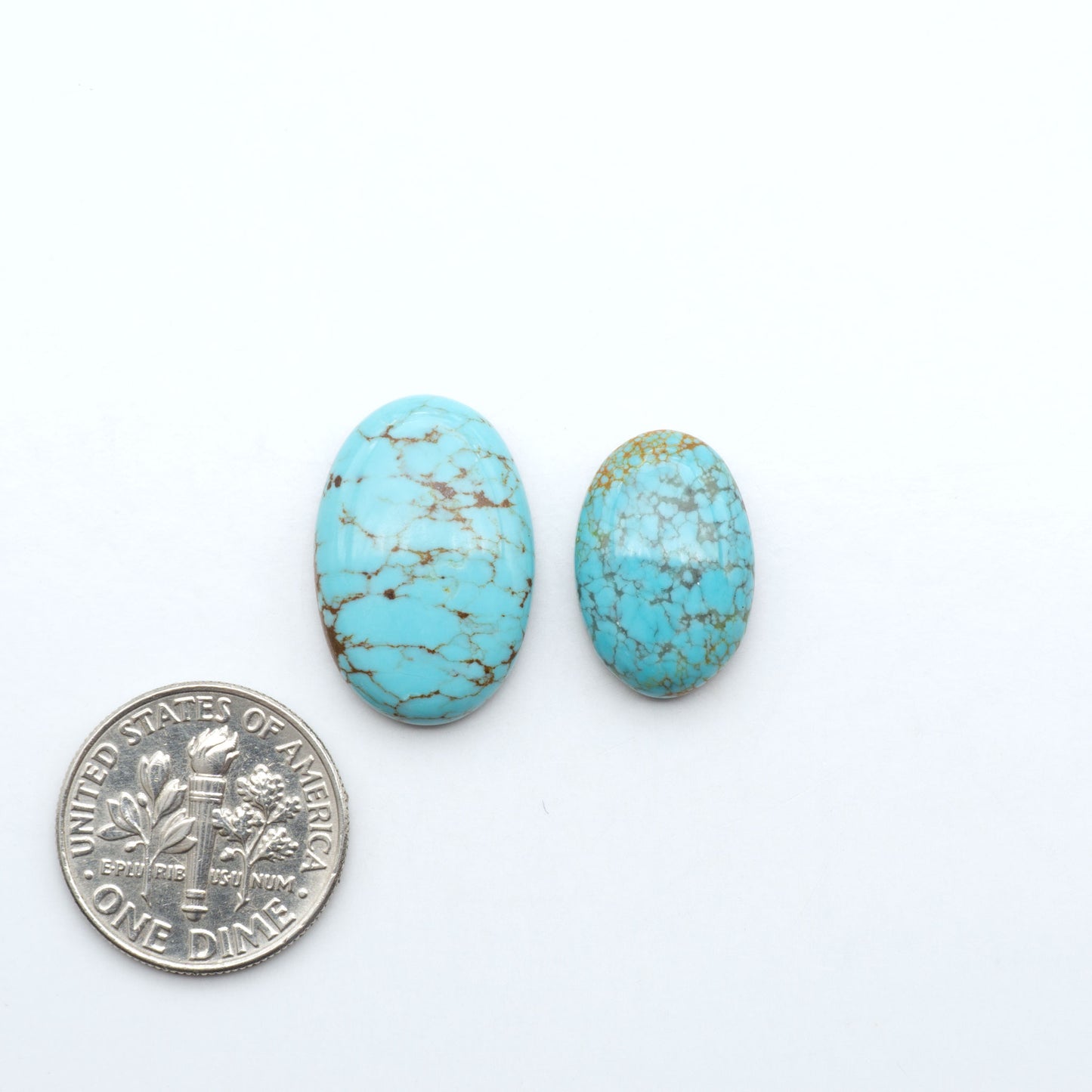 Number 8 Turquoise cabochons, blue and green color with brown matrix, polished stones on a white background, with a US dime for scale