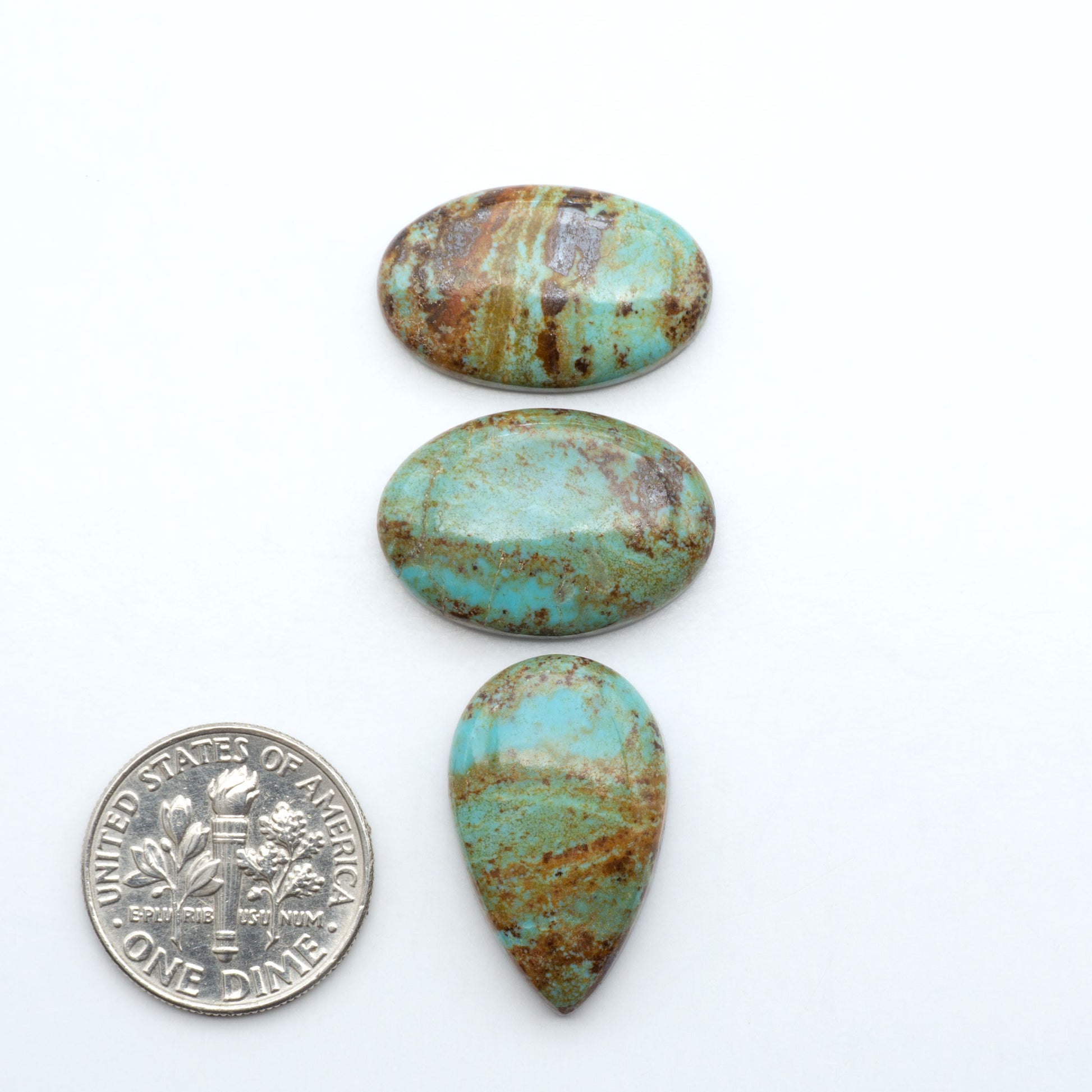 Number 8 Turquoise cabochons, blue and green color with brown matrix, polished stones on a white background, with a US dime for scale
