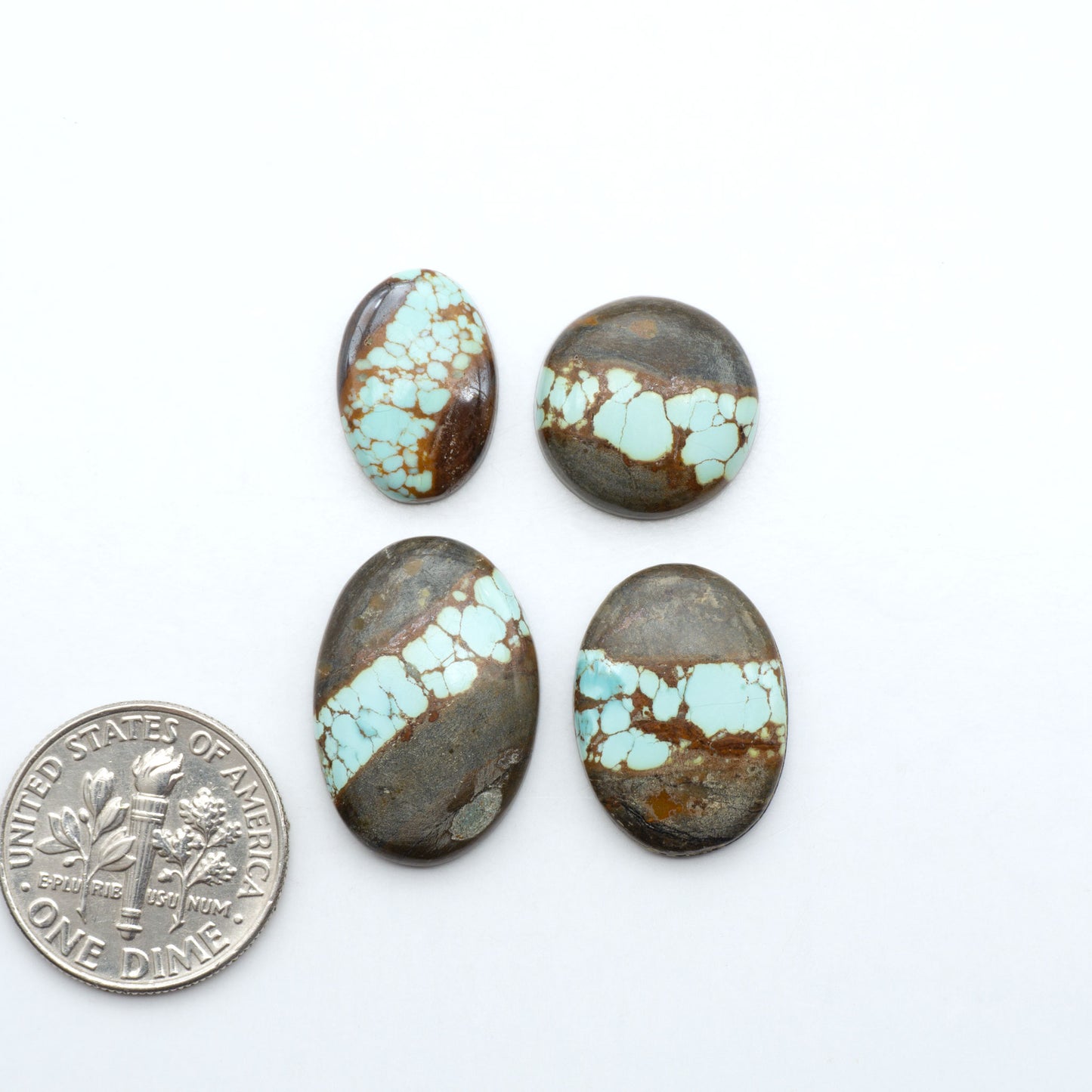 Number 8 Turquoise cabochons, blue and green color with brown matrix, polished stones on a white background, with a US dime for scale