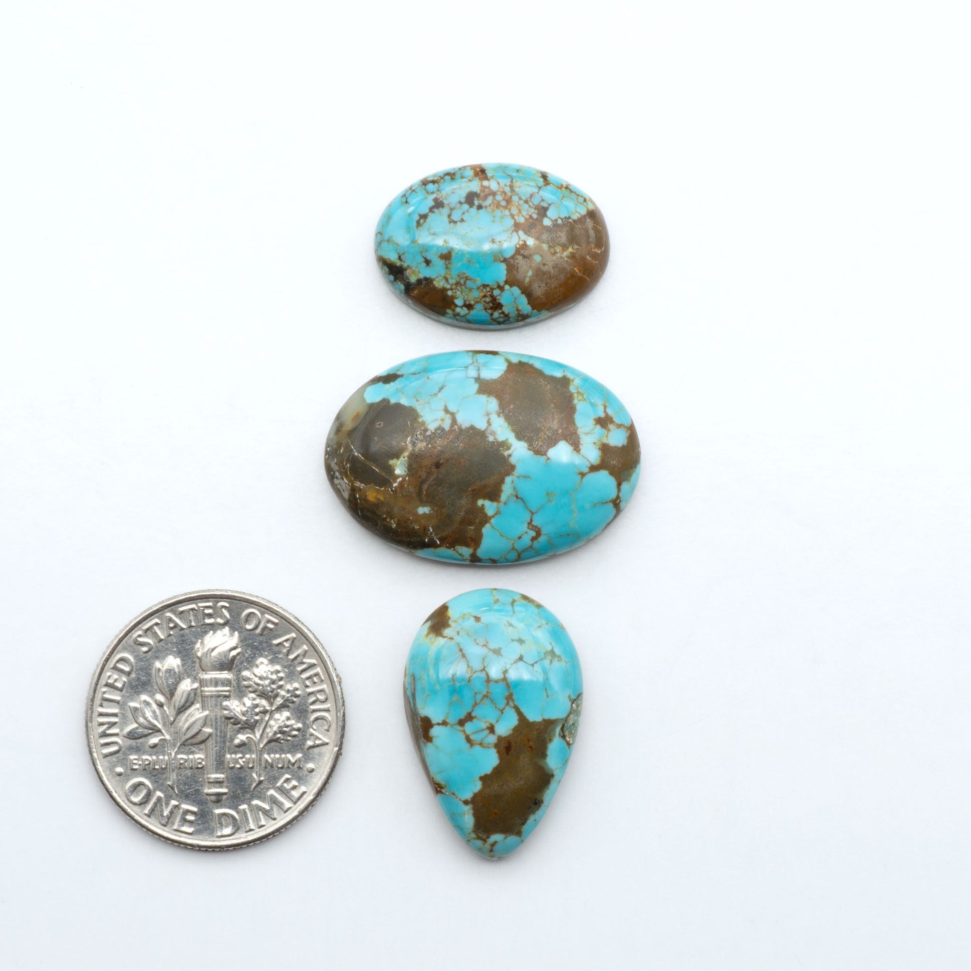 Number 8 Turquoise cabochons, blue and green color with brown matrix, polished stones on a white background, with a US dime for scale