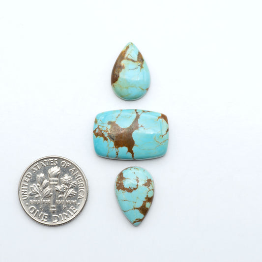 Number 8 Turquoise cabochons, blue and green color with brown matrix, polished stones on a white background, with a US dime for scale