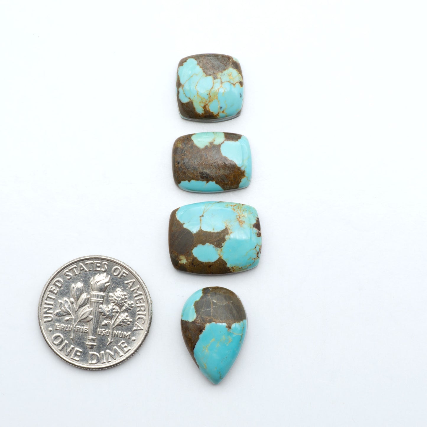 Number 8 Turquoise cabochons, blue and green color with brown matrix, polished stones on a white background, with a US dime for scale