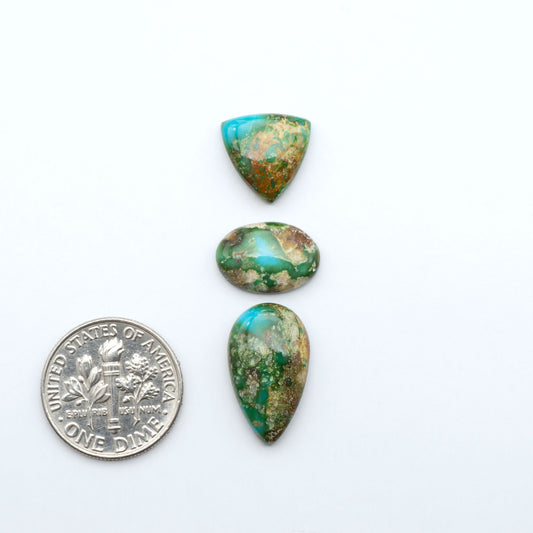 Sonoran Mountain Turquoise cabochons, blue-green color with natural matrix, polished stones on a white background, with a US dime for scale
