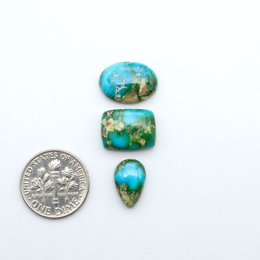 Sonoran Mountain Turquoise cabochons, blue-green color with natural matrix, polished stones on a white background, with a US dime for scale