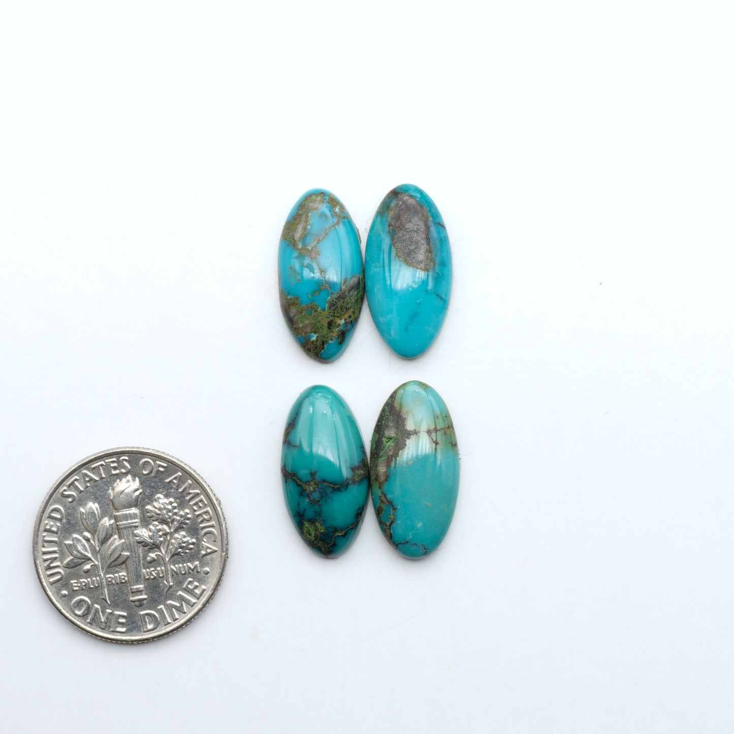 Hubei Cloud Mountain Turquoise cabochons, blue and green color with black matrix, polished stones on a white background with a US dime for scale