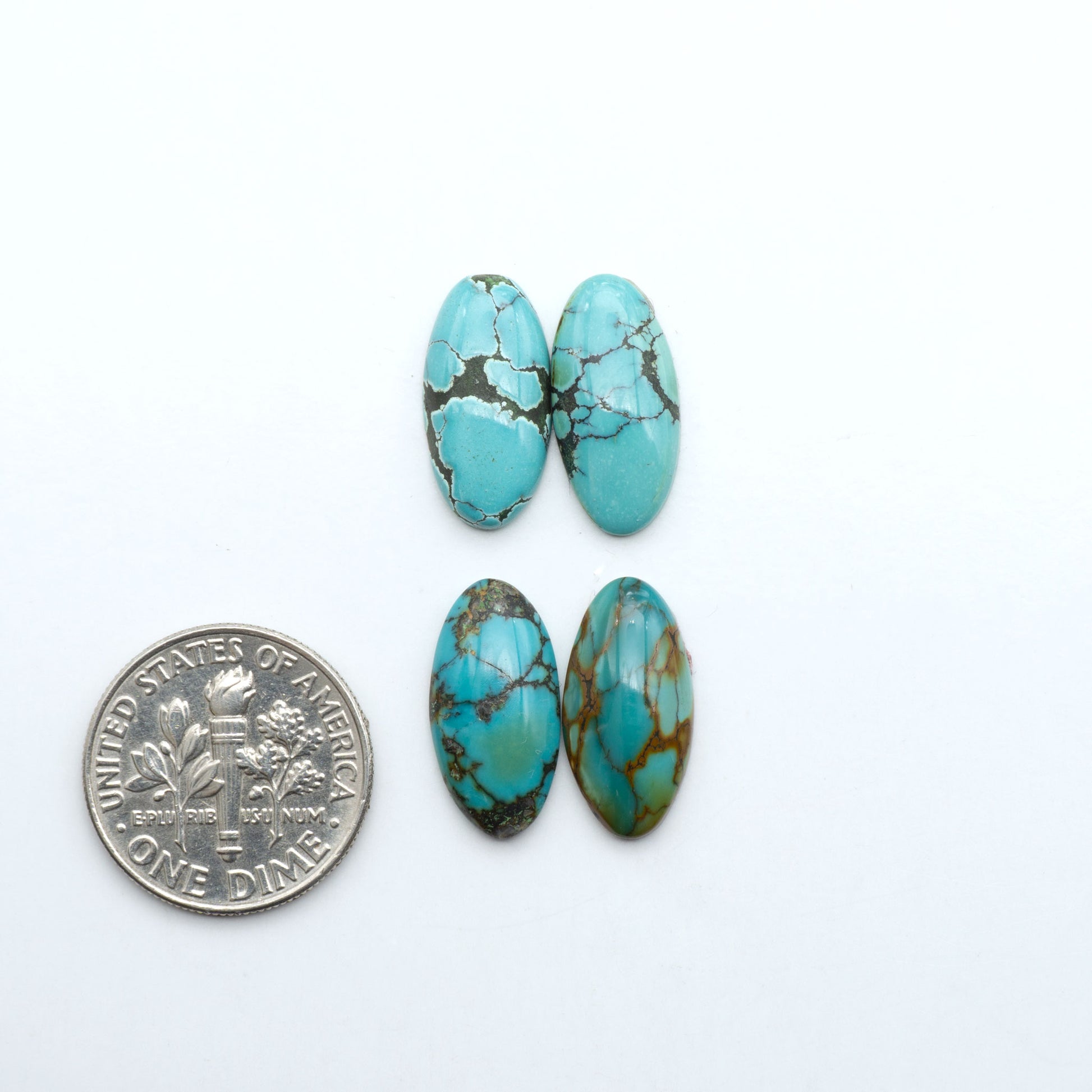 Hubei Cloud Mountain Turquoise cabochons, blue and green color with black matrix, polished stones on a white background with a US dime for scale