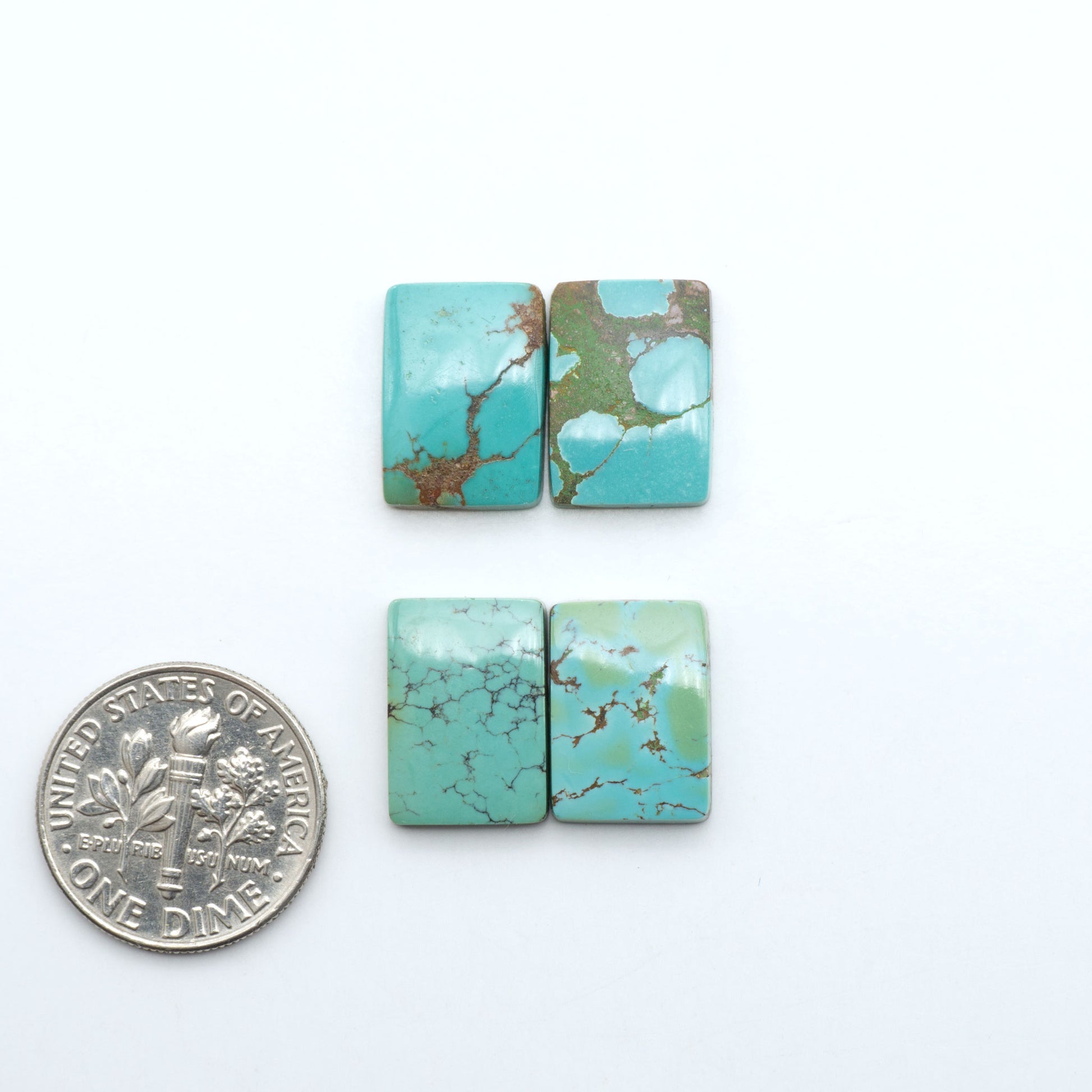 Hubei Cloud Mountain Turquoise cabochons, blue and green color with black matrix, polished stones on a white background with a US dime for scale