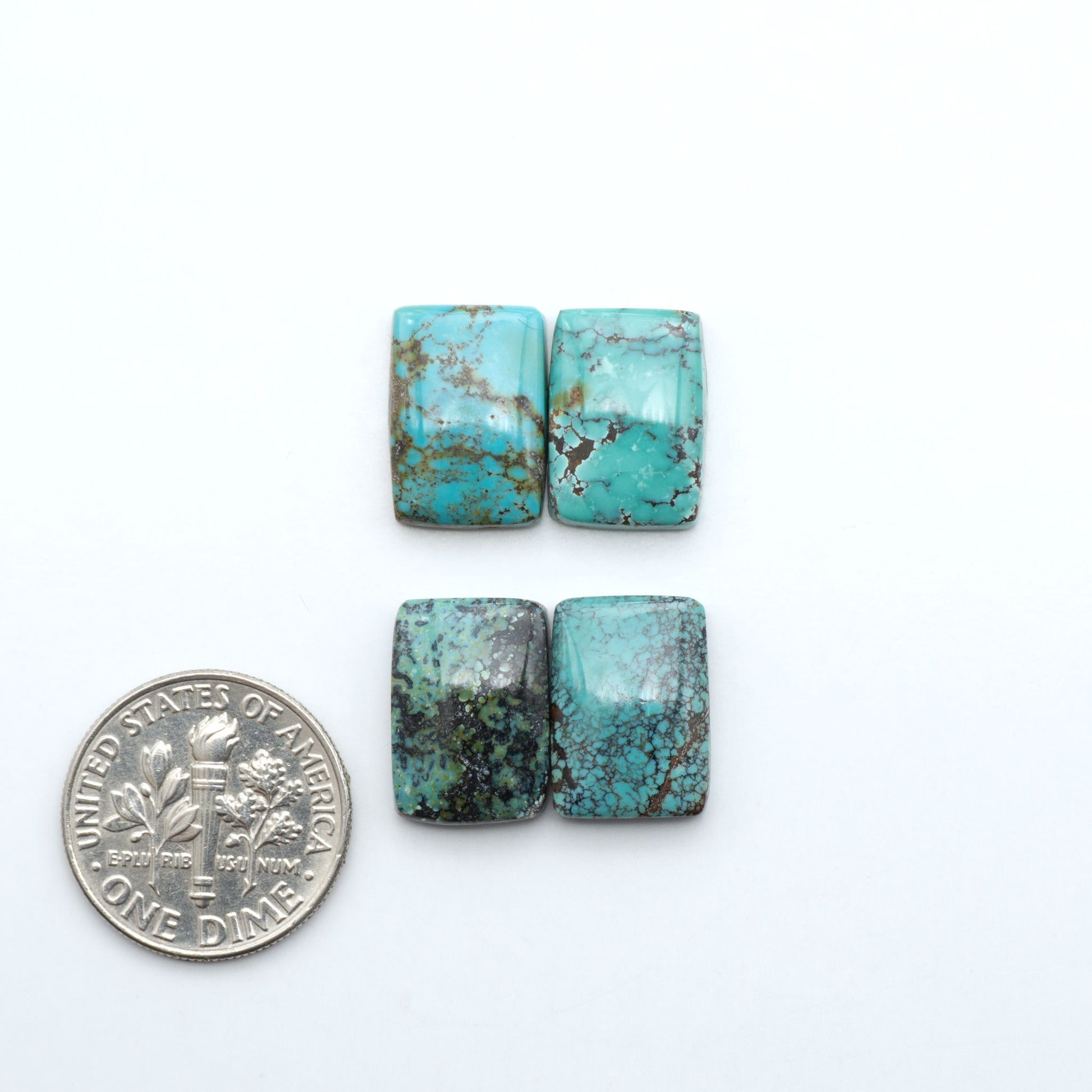 Hubei Cloud Mountain Turquoise cabochons, blue and green color with black matrix, polished stones on a white background with a US dime for scale
