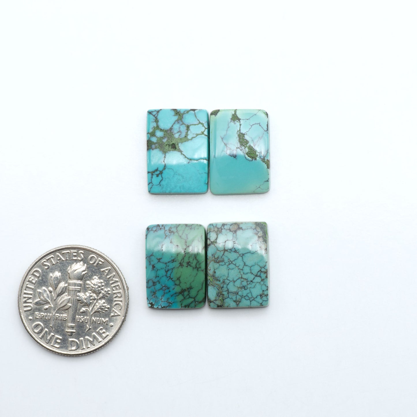 Hubei Cloud Mountain Turquoise cabochons, blue and green color with black matrix, polished stones on a white background with a US dime for scale