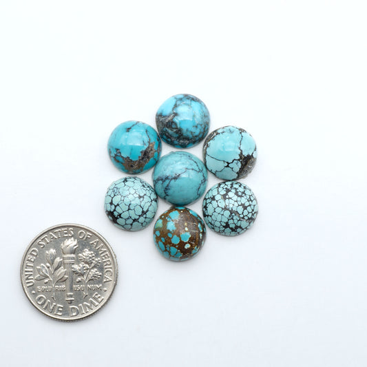 Hubei Cloud Mountain Turquoise cabochons, blue and green color with black matrix, polished stones on a white background with a US dime for scale